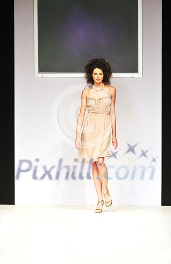 young beautiful model walking on fashion show piste