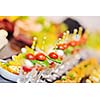 buffed food closeup of  fruits, vegetables, meat and fish arranged on banquet table