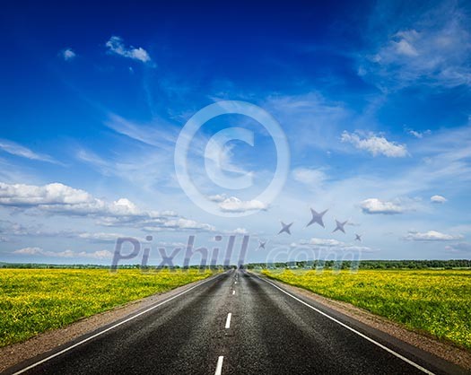Travel concept background - road in blooming spring meadow