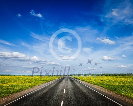 Travel concept background - road in blooming spring meadow Travel concept background - road in blooming spring meadow
