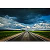 Travel concept background - road and stormy sky