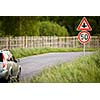 Car on a country road with limited speed and crossroad sign