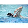 Young man swimming the front crawl in a pool