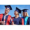 young graduates students group  standing in front of university building on graduation day