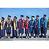 young graduates students group  standing in front of university building on graduation day