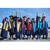 young graduates students group  standing in front of university building on graduation day