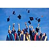 high school students graduates tossing up hats over blue sky.