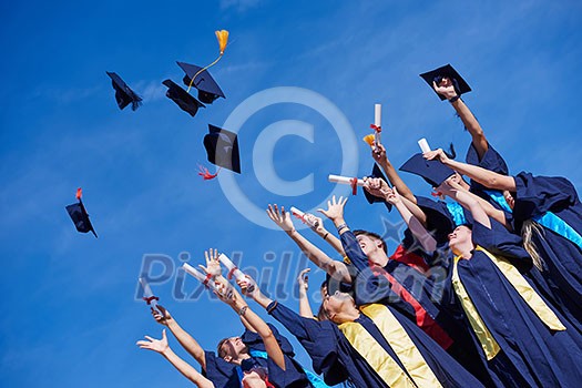 high school students graduates tossing up hats over blue sky. high school students graduates tossing up hats over blue sky.