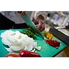 chef in hotel kitchen  slice  vegetables with knife and prepare food