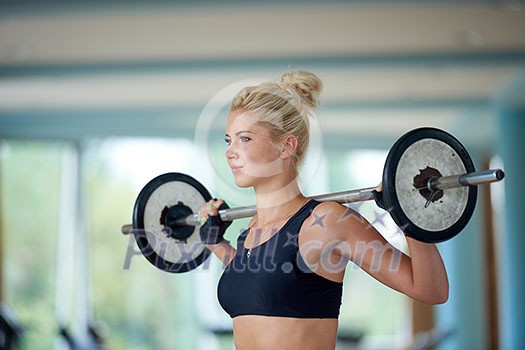 healthy and fit young woman in fitness gym lifting weights and working on her butt muscles healthy and fit young woman in fitness gym lifting weights and working on her butt muscles