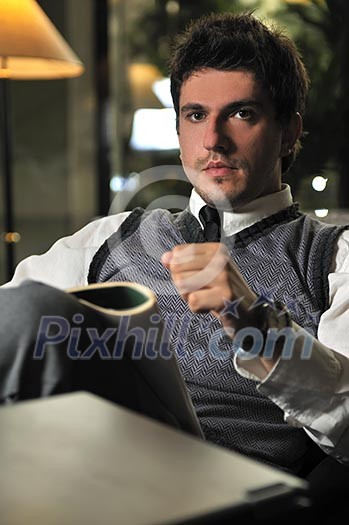 young businessman reading newspapper at luxury caffe