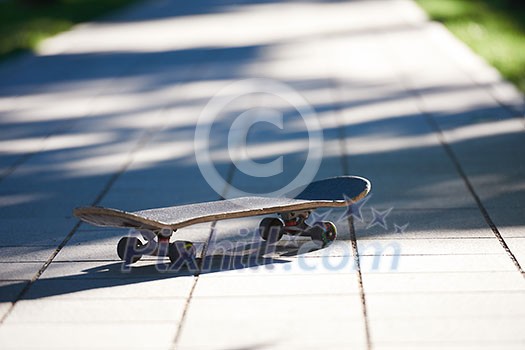 Old used skateboard isolated on the ground on street Old used skateboard isolated on the ground on street