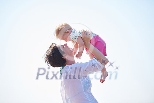 happy mom and baby on beach  have fun while learning to walk and  make first steps