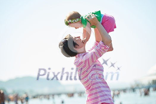 happy mom and baby on beach  have fun while learning to walk and  make first steps