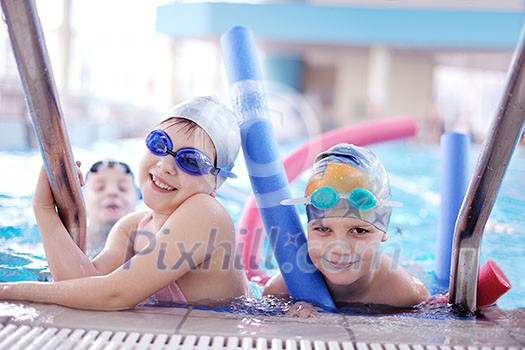 happy children kids group  at swimming pool class  learning to swim