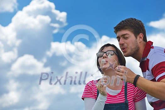 Portrait of romantic young couple in love smiling together outdoor in nature with blue sky in background Portrait of romantic young couple in love smiling together outdoor in nature with blue sky in background