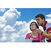 Portrait of romantic young couple in love  smiling together outdoor in nature with blue sky in background