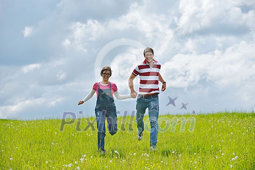 Portrait of romantic young couple in love smiling together outdoor in nature with blue sky in background Portrait of romantic young couple in love smiling together outdoor in nature with blue sky in background