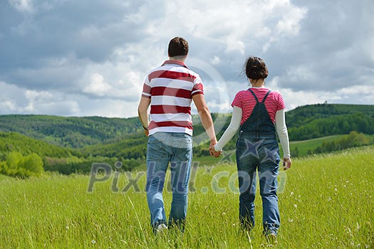 Portrait of romantic young couple in love smiling together outdoor in nature with blue sky in background Portrait of romantic young couple in love smiling together outdoor in nature with blue sky in background