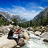 Hiker trekkers read a trekking map on trek in Himalayas mountains. Himachal Pradesh,India