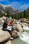 Hiker trekkers read a trekking map on trek in Himalayas mountains. Himachal Pradesh,India