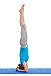 Yoga - young beautiful woman yoga instructor doing headstand (sirsasana) asana exercise isolated on white background