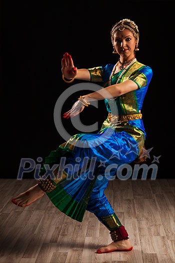 Young beautiful woman dancer exponent of Indian classical dance Bharatanatyam in Shiva pose Young beautiful woman dancer exponent of Indian classical dance Bharatanatyam in Shiva pose
