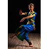 Young beautiful woman dancer exponent of Indian classical dance Bharatanatyam in Shiva pose