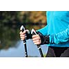 Nordic walking exercise adventure hiking concept - closeup of woman's hand holding nordic walking poles