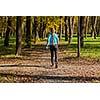 Nordic walking adventure and exercising concept - woman hiking withnordic walking poles in park