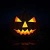 Halloween concept design background - scary Jack-o'-lantern carved pumpkin with candle light inside