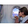 happy young  tourist  woman is sitting in the airplane looking window and travel to summer vacation