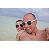 happy young couple have fun and relax at summer vacation on background maldives travel location and beautiful white sand beach