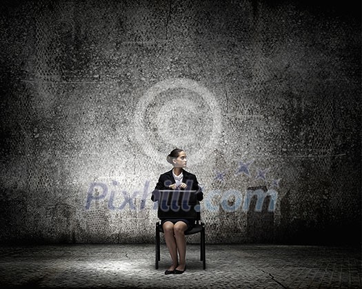 Young thoughtful confused businesswoman sitting on chair