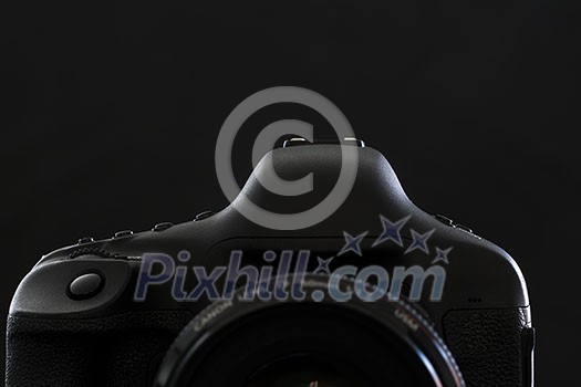 Professional modern DSLR camera low key stock photo/image - Modern DSLR camera with a very wide aperture lens on with highlighted edges against black background Professional modern DSLR camera low key stock photo/image - Modern DSLR camera with a very wide aperture lens on with highlighted edges against black background