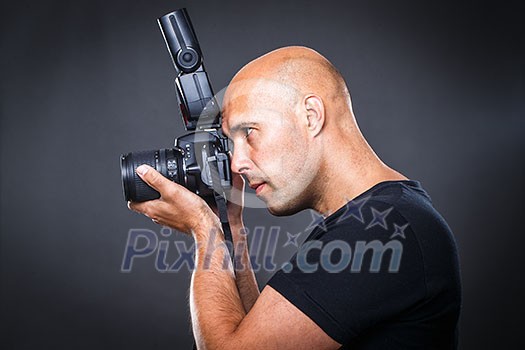 Young, pro male photographer in his studio during a photo shoot (color toned image; shallow DOF) Young, pro male photographer in his studio during a photo shoot (color toned image; shallow DOF)