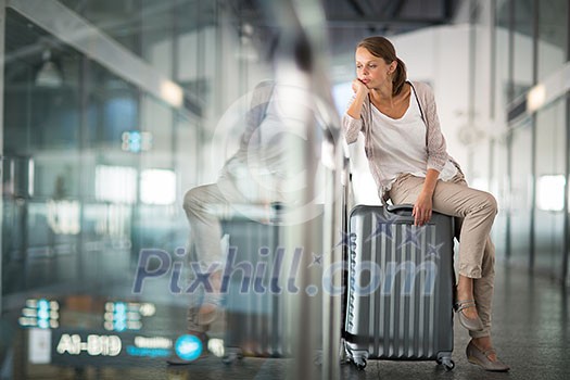 Young female passenger at the airport, about to check-in Young female passenger at the airport, about to check-in