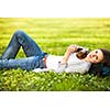 Young woman using her tablet computer while relaxing outdoors in a park on a lovely spring day