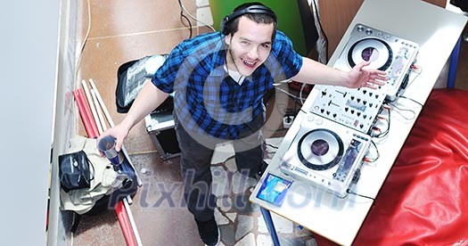 young dj man with headphones and compact disc dj equipment on party event