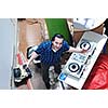 young dj man with headphones and compact disc dj equipment on party