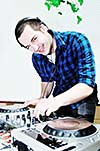 young dj man with headphones and compact disc dj equipment on party