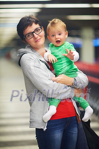 young mother with baby in shopping mall supermarket store buying food and grocery