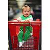happy smilling baby child in grocery supermarket store  shopping cart