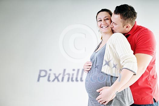 young family couple together in studio isolated on white. happy and waiting for baby