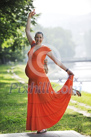 beautiful young happy pregnant woman outdoor in bright nature in orange dress beautiful young happy pregnant woman outdoor in bright nature in orange dress