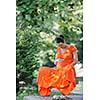 beautiful young happy pregnant woman outdoor in bright nature in orange dress