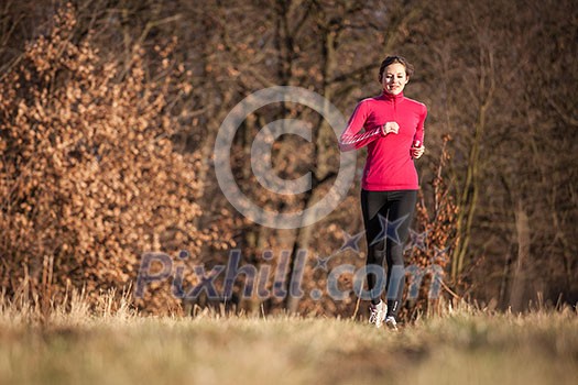 Young woman running outdoors on a lovely sunny winter/fall day