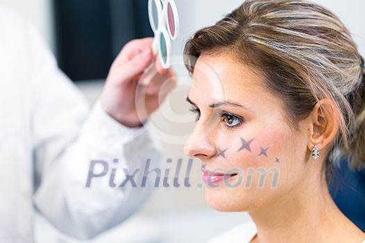 Optometry concept - pretty young woman having her eyes examined by an eye doctor/optometrist (color toned image; shallow DOF) Optometry concept - pretty young woman having her eyes examined by an eye doctor/optometrist (color toned image; shallow DOF)