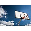 Basketball hoop against  lovely blue summer sky with some fluffy white clouds