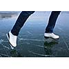 Young woman ice skating outdoors on a pond on a freezing winter day